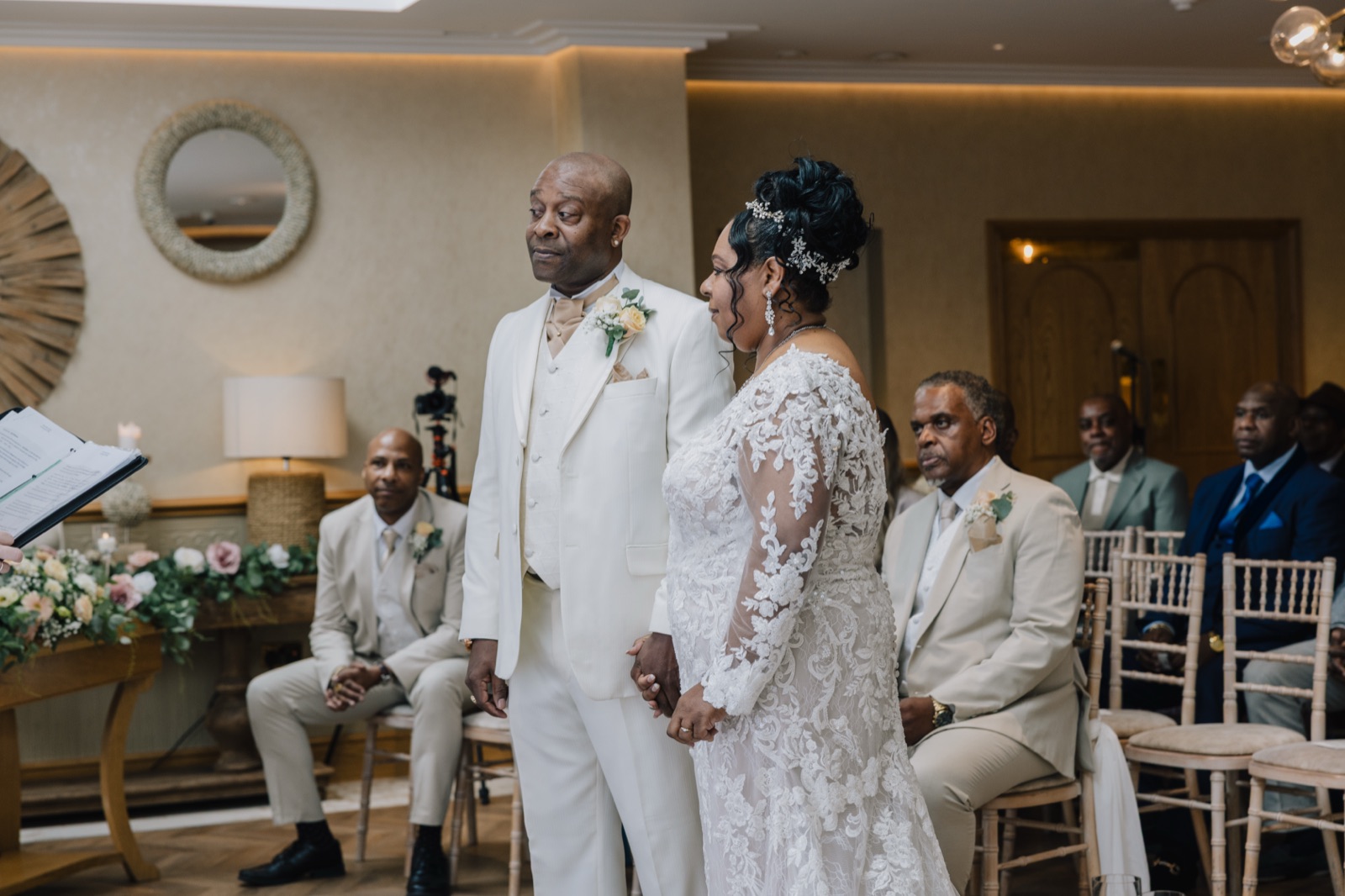 Carl and Tracey holding hands during their wedding ceremony in the Garden Rooms at Fairlawns Hotel