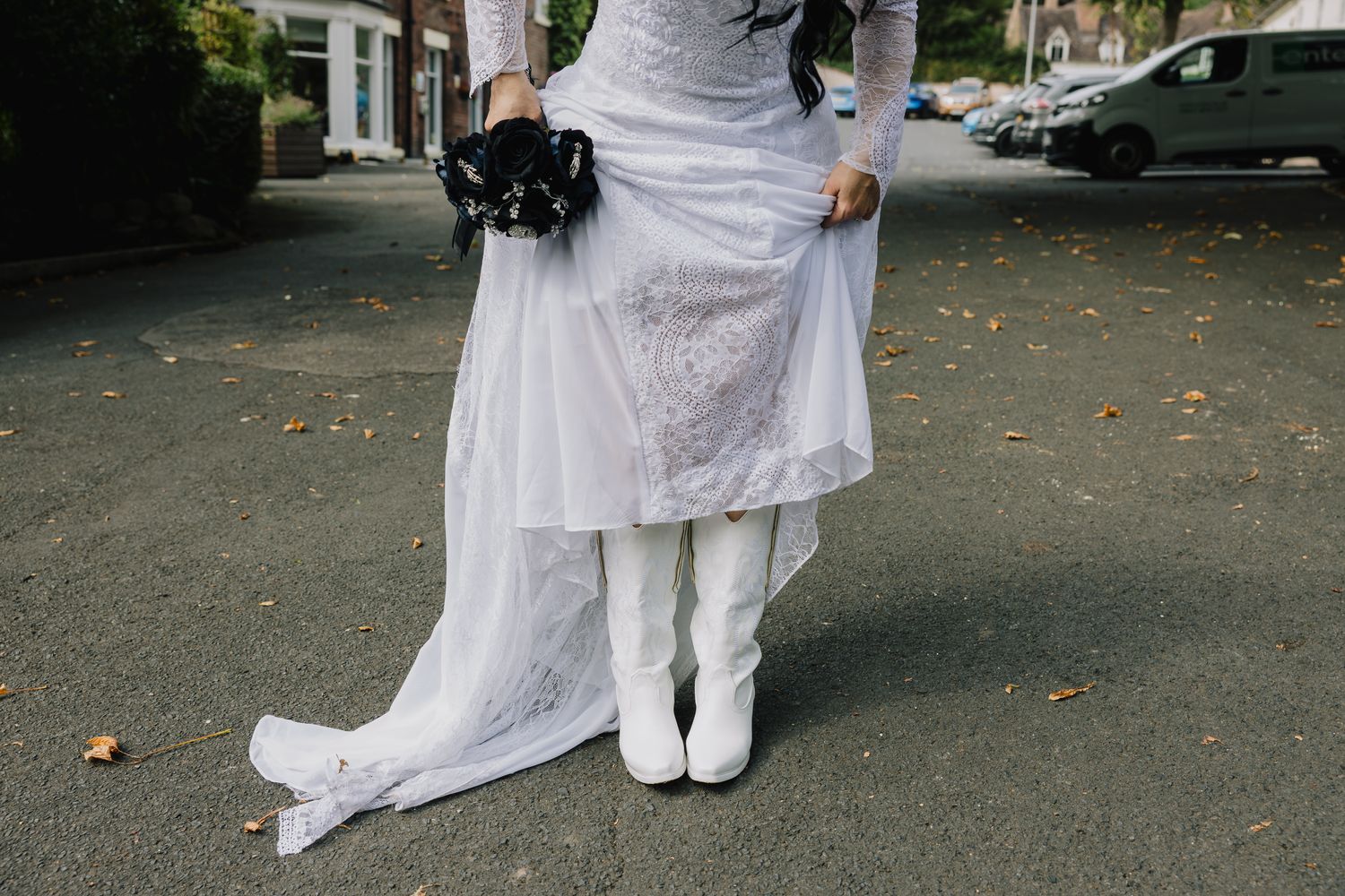 Bride lifting her lace dress to reveal white cowboy boots at the Valley Hotel, Ironbridge