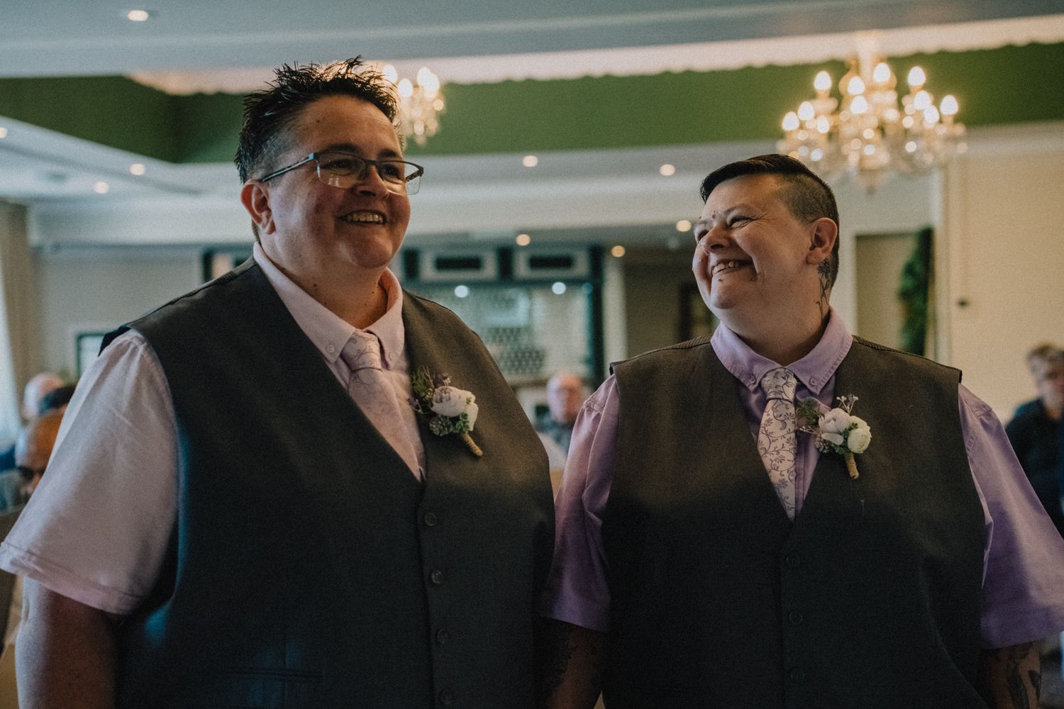 Lyn and Nic laughing together at the front of the room before the ceremony begins, Stone Staffordshire wedding photographer