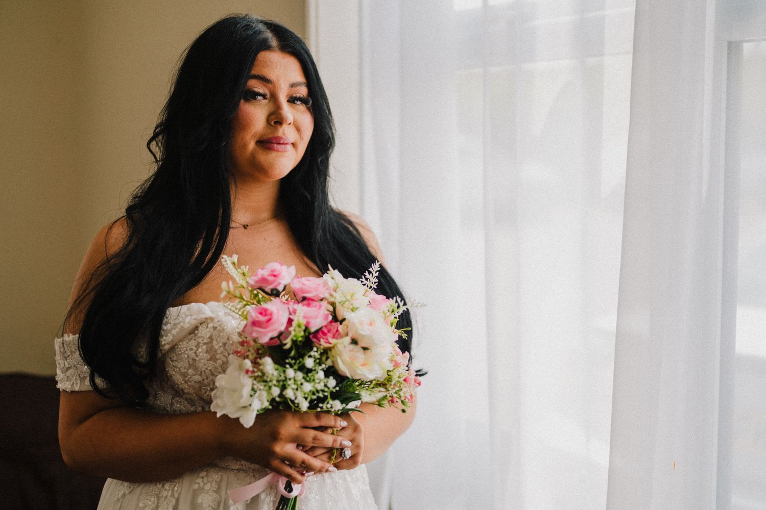 Melanie holding her pink and white bouquet in window light before the ceremony, Westbury Village Hall wedding Shropshire