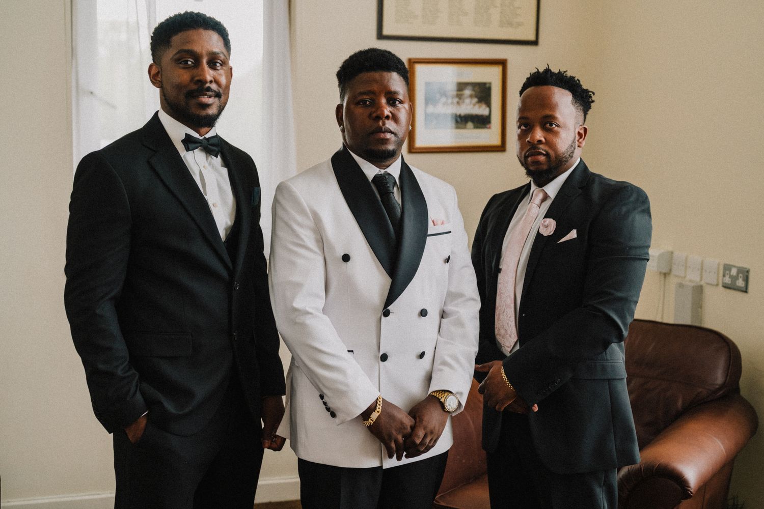 Cornelius in a white dinner jacket with his groomsmen before the ceremony, village hall wedding near Shrewsbury